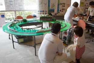 手動ハンドルを回して生み出した電気を使ってHOゲージの鉄道模型を動かした。