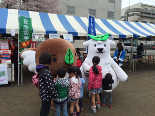 日野市のエコキャラクター・エコアラ®（左）とエコクマ®（右）も地域の祭りやイベントに参加して、事業のPR。
エコアラ®は、東京都日野市の多摩動物公園の生まれ。地球温暖化に心を痛め、エコレンジャーとなった。一方、地球温暖化で住んでいるところを追われ、東京都日野市にやってきたエコクマ®は、偶然出会ったエコアラ®の果敢なエコ活動に触発され、エコレンジャーとなった。頭の葉っぱは、エコアラ®から仲間の証にもらったものだ。