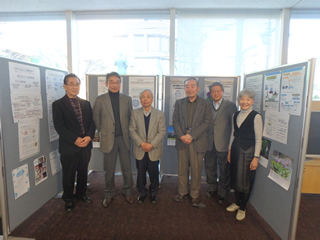 地球温暖化防止キャンペーンのパネル展示を前にする「ふっさ環境市民会議」のメンバーたち。