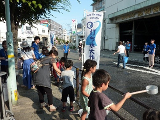 打ち水キャンペーンの一環として実施した、打ち水大作戦inエコポリ2017で水を撒く子どもたち。