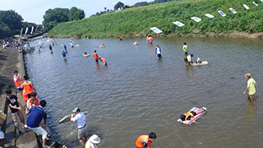 ペットボトルで作ったボートに乗って、堰止めした川の上流から下流に向けて流れていく「ボート遊び体験」
