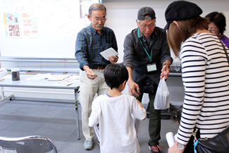 別会場のスペース105では、市内の雑木林から捕ってきたカブトムシの幼虫を配布。13時からの配布に合わせて集まってきた子どもたちは、昆虫やカブトムシについてのレクチャーを聞く。地球上にいる生物の4分の3が昆虫で、約100万種もいると聞き、驚きの表情を浮かべる。