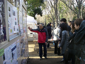 写真１１　来園者にかいぼりについて伝えるボランティア