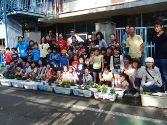 グリーンウェイブ2013に参加して植え付けたプランターを前に、この日の参加者全員で記念撮影。