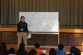 収穫祭のこの日、等々力小学校の5年生3クラスが体育館に集まって、講師の小野寺ひかるさんの話を聞いて、『田んぼから生まれたものが、人の暮らしを支えながら自然界に還っていく様子』を学んだ。