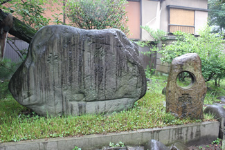 三囲神社にある宝井其角「ゆふたちや」の句碑（雨乞いの碑）。石碑の文字は明瞭ではないが、「遊ふた地や田を見めぐりの神ならば」と刻まれているという。