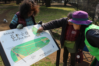 看板を見ながら、花壇の場所について説明。