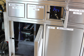 バッテリーと鍵が収納されている金属ロッカー。（扉の開錠前／扉が開くとバッテリー及び鍵が取り出せるようになる）