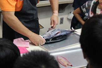 ぐいっと包丁の刃を差し込んで、カツオを切っていく。
