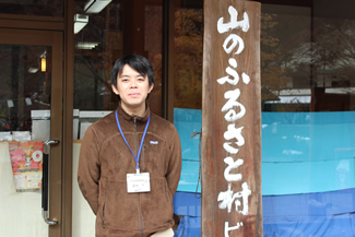 山のふるさと村ビジターセンターのレンジャー、菅原遊さん（ビジターセンター前にて）。