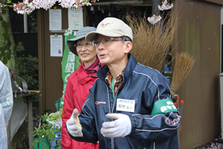 日曜日の朝10時に集まってきた会員・ボランティアへ作業の説明をする、代表の田中雅文さん。