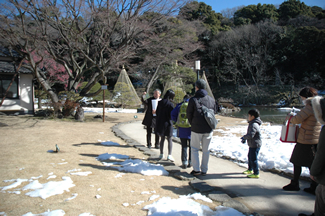 雪が残る庭園で、野鳥観察会の始まり。この直後に、青空に羽ばたくオオタカを観察できた。